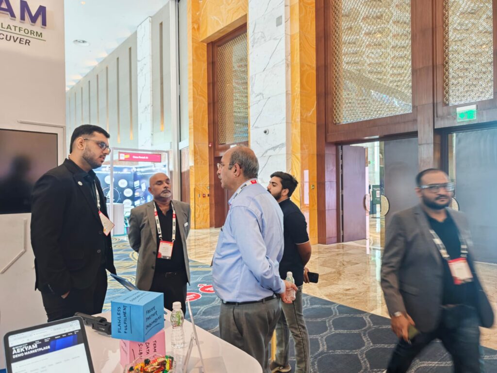 Aekyam team members engaging with a visitor at their exhibition booth