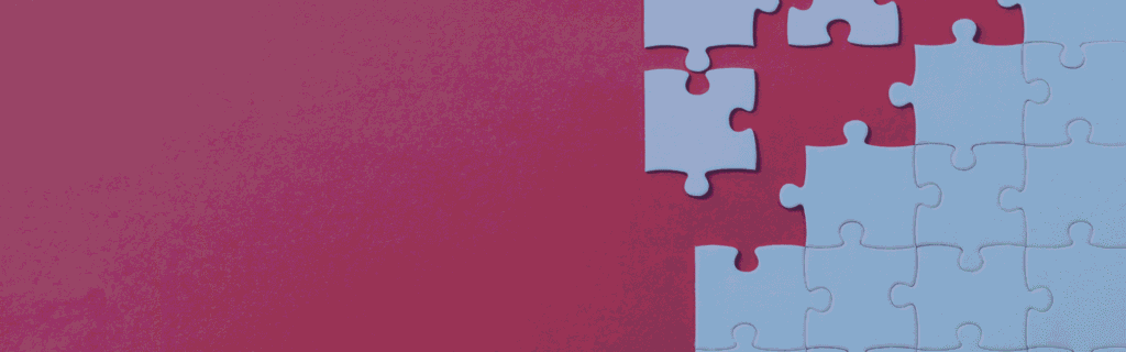 An abstract image of a puzzle, with blank white jigsaw pieces arranged on a vivid red background.