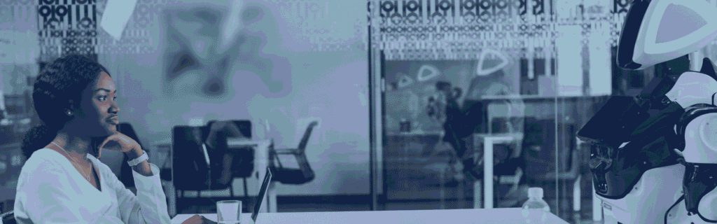 A businesswoman working on her laptop, with a humanoid robot sitting across