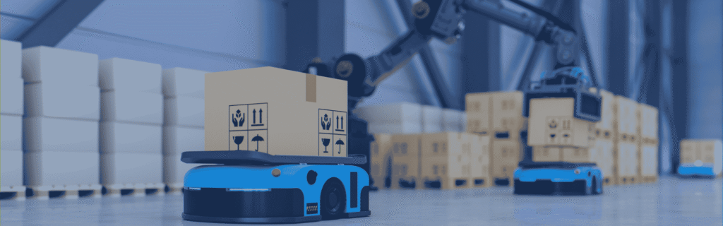 Autonomous mobile robots transport cardboard boxes across a warehouse floor while a robotic arm handles inventory in the background