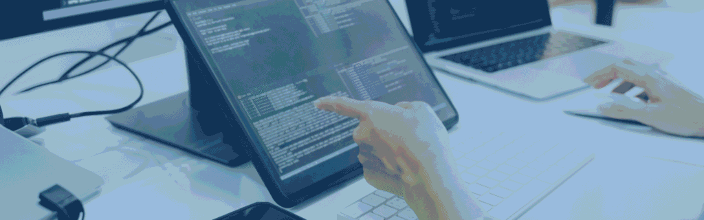 Close-up of a person's hand pointing at code on a tablet screen