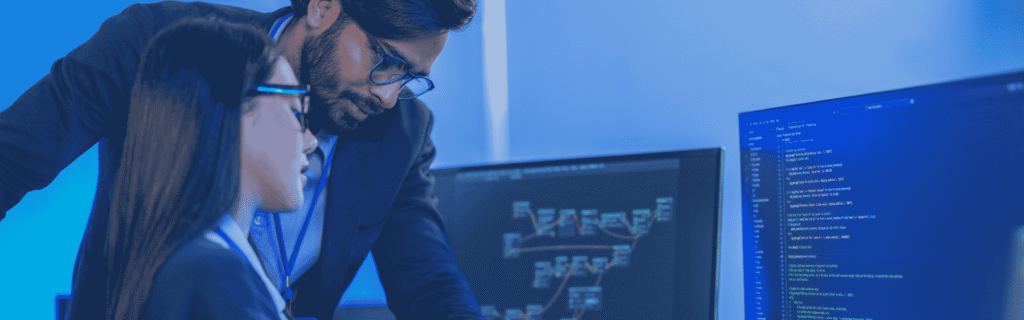 Two software developers, reviewing code together at a desk