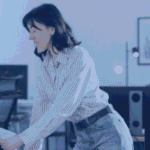 Colleagues in an open-plan office reviewing workflows on monitors