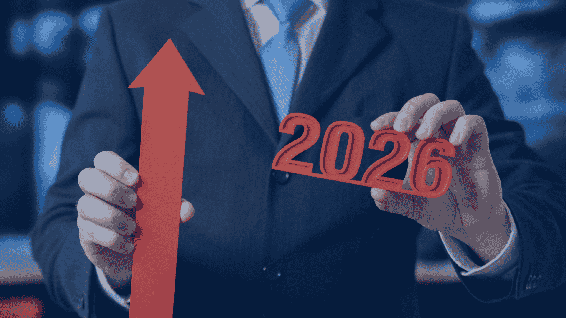 Red upward arrow and 2026 lettering held by a business professional in a suit.